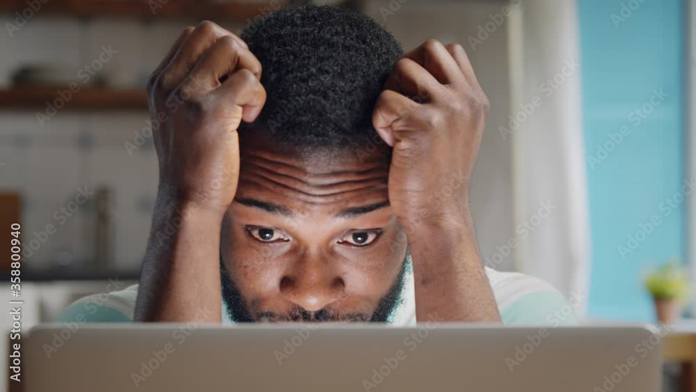 Depressed african businessman having problems with work sitting at home