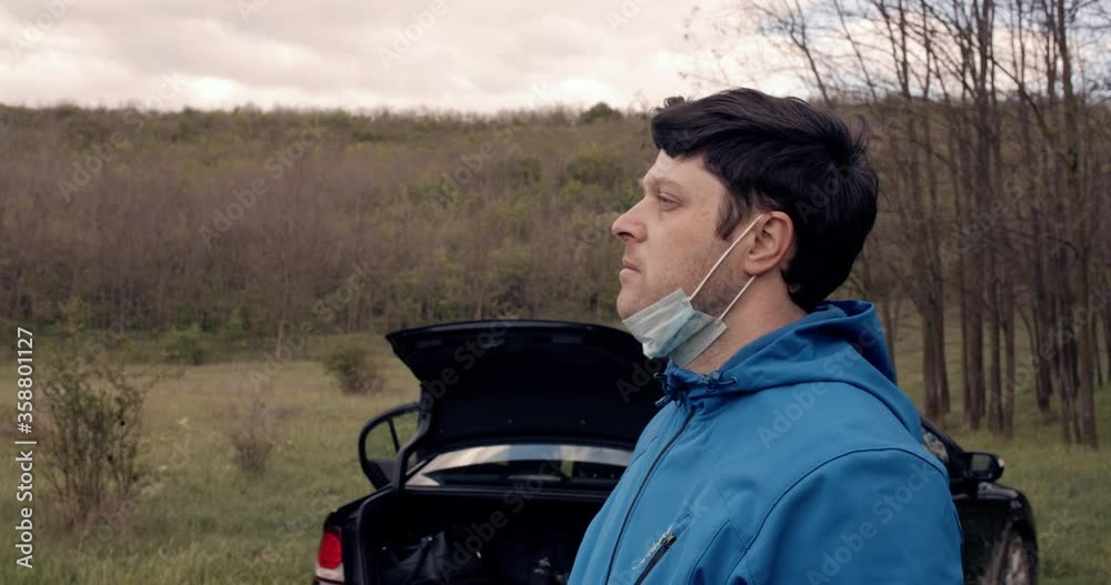 a depressed and thoughtful man with a face mask on his face. a depressed and thoughtful man with a face mask on his face.