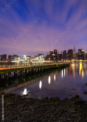 View o Midtown Manhattan from East river pier at dawn with long exposure