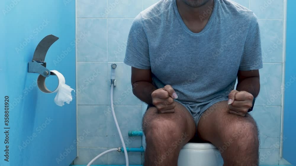 Young asian man have stomach ache and defecation and watch wristwatch in rush hour, Concept digestive problems and difficulties in the toilet