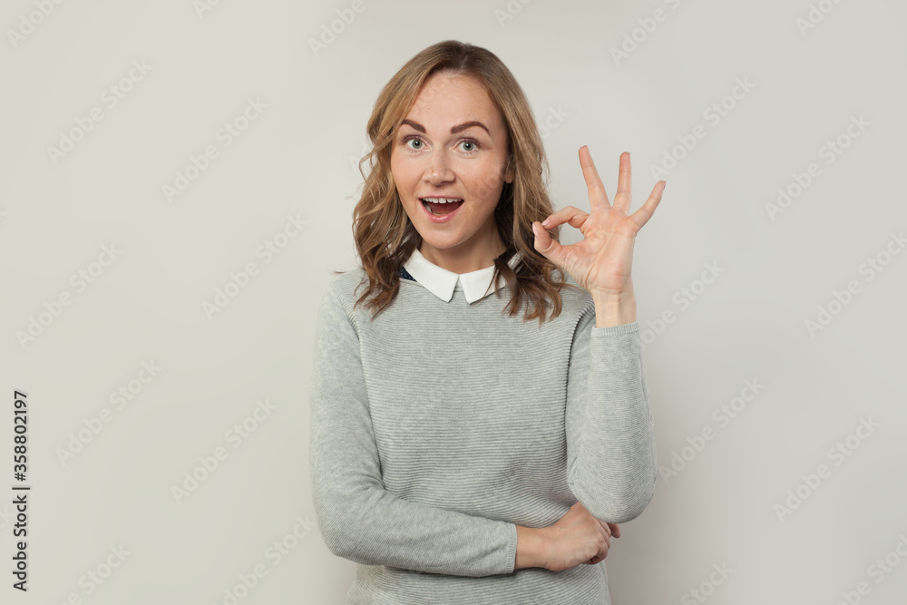 Happy excited woman ok sign on white background Happy excited woman ok sign on white background