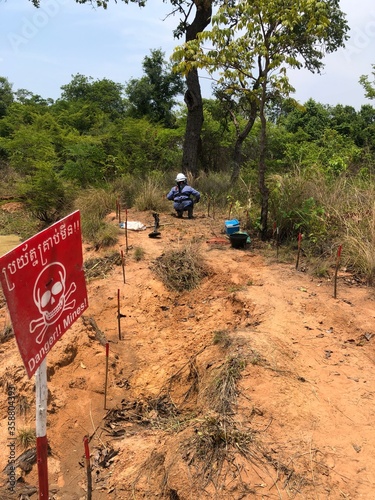 Female deminer in a minefield photo