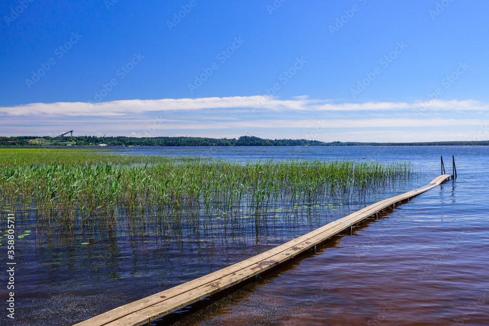 Wooden pier on the lake. Kavgolovskie lake is a popular vacation spot near the village of Toksovo, Leningrad region, Russia
