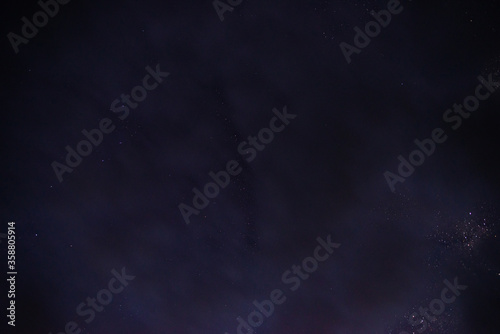 Obraz na płótnie Stars in the night sky through the clouds on a summer night w salonie