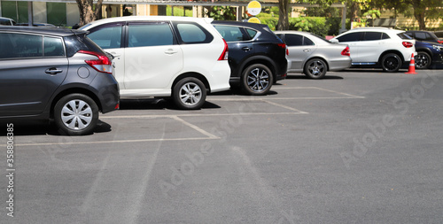 Closeup of rear, back side of black car with  other cars parking in outdoor parking in bright sunny day.  © Amphon