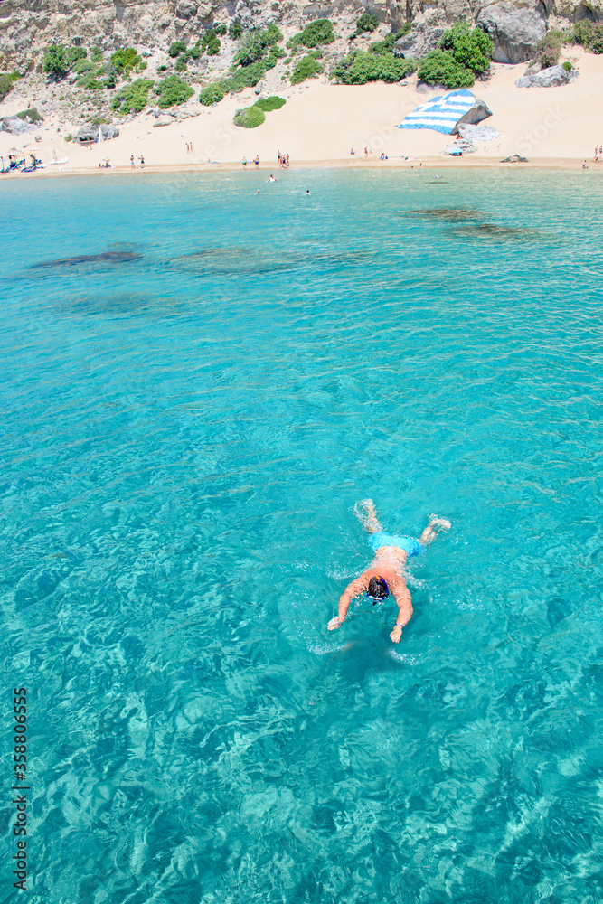 Man snorkels from Tsambika beach (RHODES, GREECE)