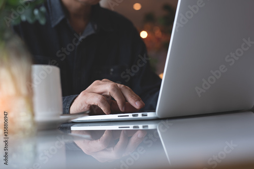 Casual man freelancer online working via laptop computer in coffee shop 