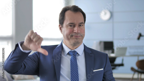 Thumbs Down by Middle Aged Businessman