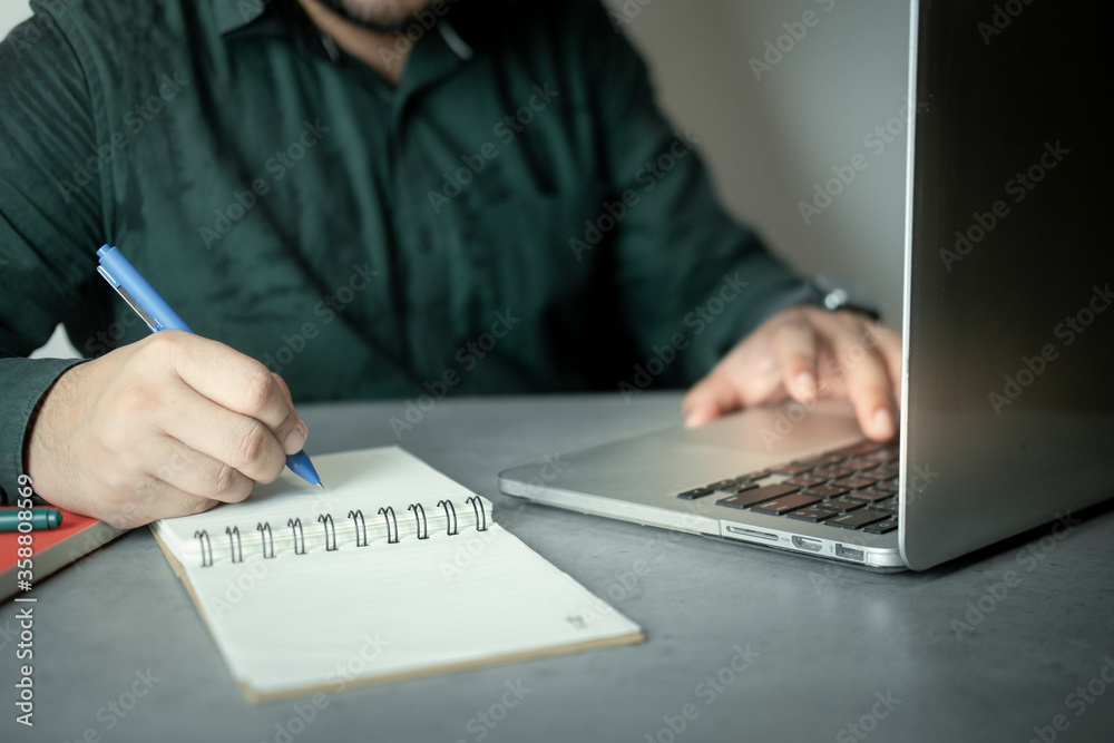 Man sliding on keyboard of laptop for check order and note to preparation sent order. Man sliding on keyboard of laptop for check order and note to preparation sent order.
