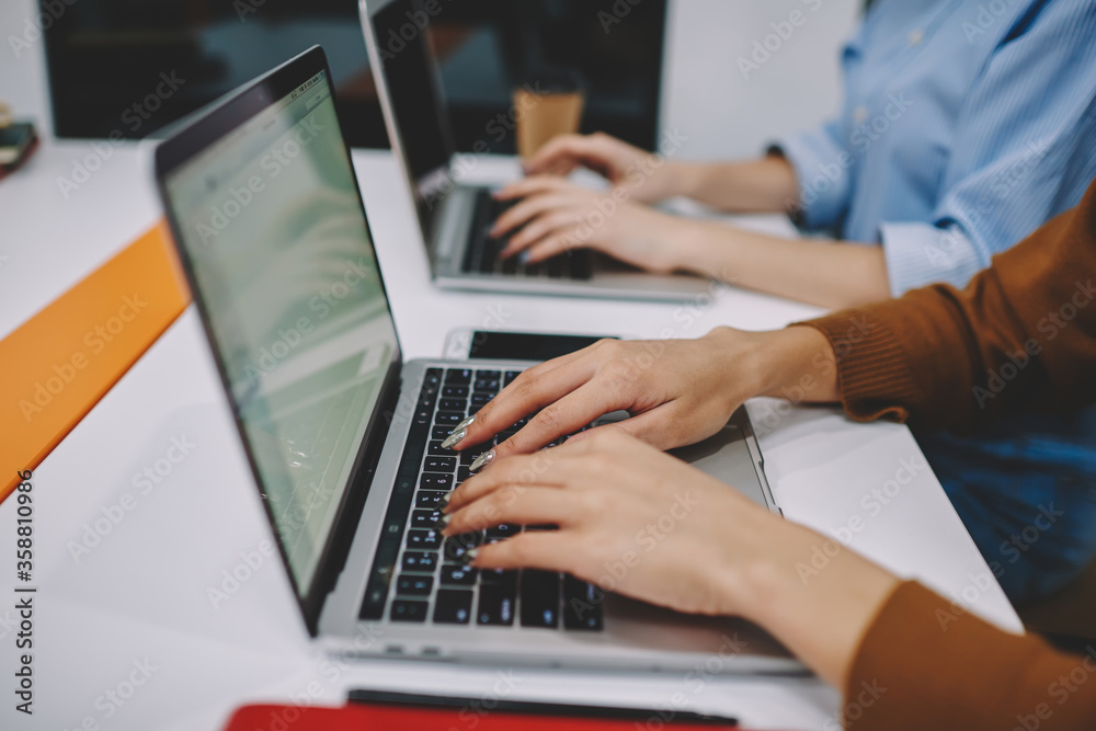Cropped image of woman's hands typing on laptop computer during online working process, female keyboarding text using netbook for studying and searching information in networks via high speed wifi. Cropped image of woman's hands typing on laptop computer during online working process, female keyboarding text using netbook for studying and searching information in networks via high speed wifi.