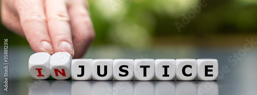 Hand turns dice and changes the word "injustice" to "justice".