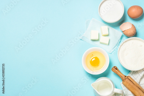 Baking ingredients at blue table top view.