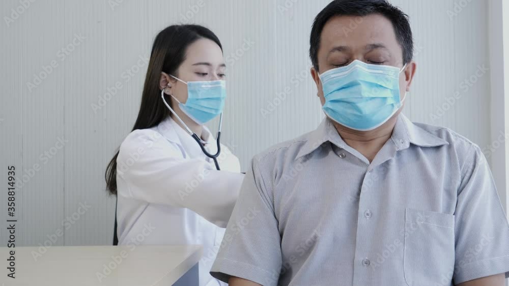 Female doctor using a stethoscope to checking lung for a middle-aged patient who has a fever and comes to see the doctor at the health care center. Female doctor using a stethoscope to checking lung for a middle-aged patient who has a fever and comes to see the doctor at the health care center.