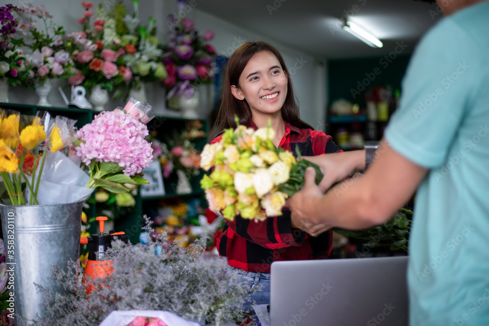Asian Woman Florist owner of a small florist business holding flowers for delivery to customers at her store