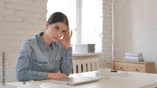 Disappointed Young Girl Reacting to Loss at Work by Closing Laptop photo