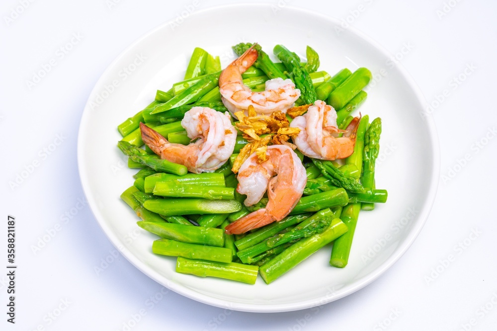 Stirred fried asparagus with shrimp served on white plate isolated on white background. famous thai food in thailand. popular food in Asia.