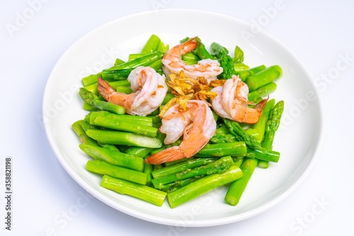 Stirred fried asparagus with shrimp served on white plate isolated on white background. famous thai food in thailand. popular food in Asia.