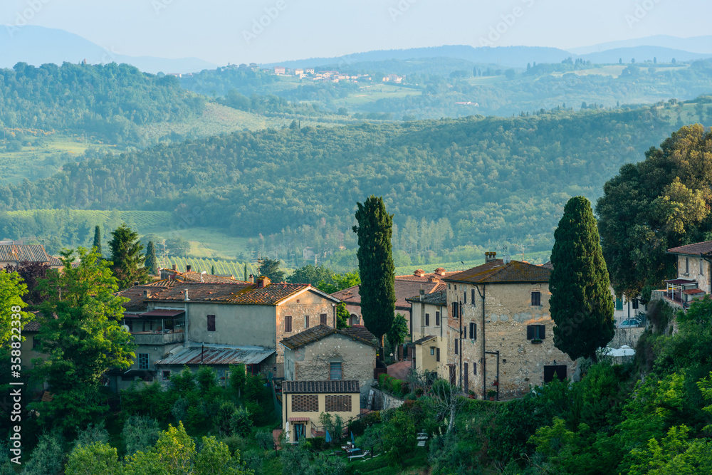 Residential buildings with a Tuscan countryside in the background in San Gimignano, Province of Siena, Italy.