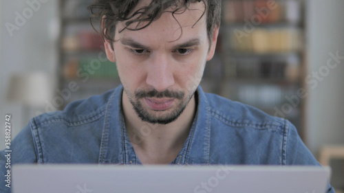 Close Up of Casual Man Working On Laptop photo