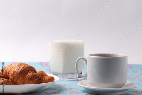 delicious french croissants and a white ceramic coffee cup 