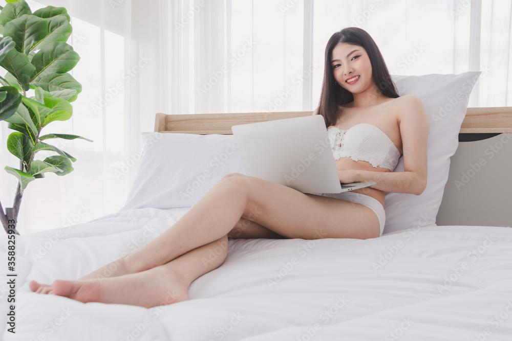 Asian beautiful girl wearing casual clothes and play or work with computer. Happily in the house. Concept Work for home and relax time. Asian beautiful girl wearing casual clothes and play or work with computer. Happily in the house. Concept Work for home and relax time.