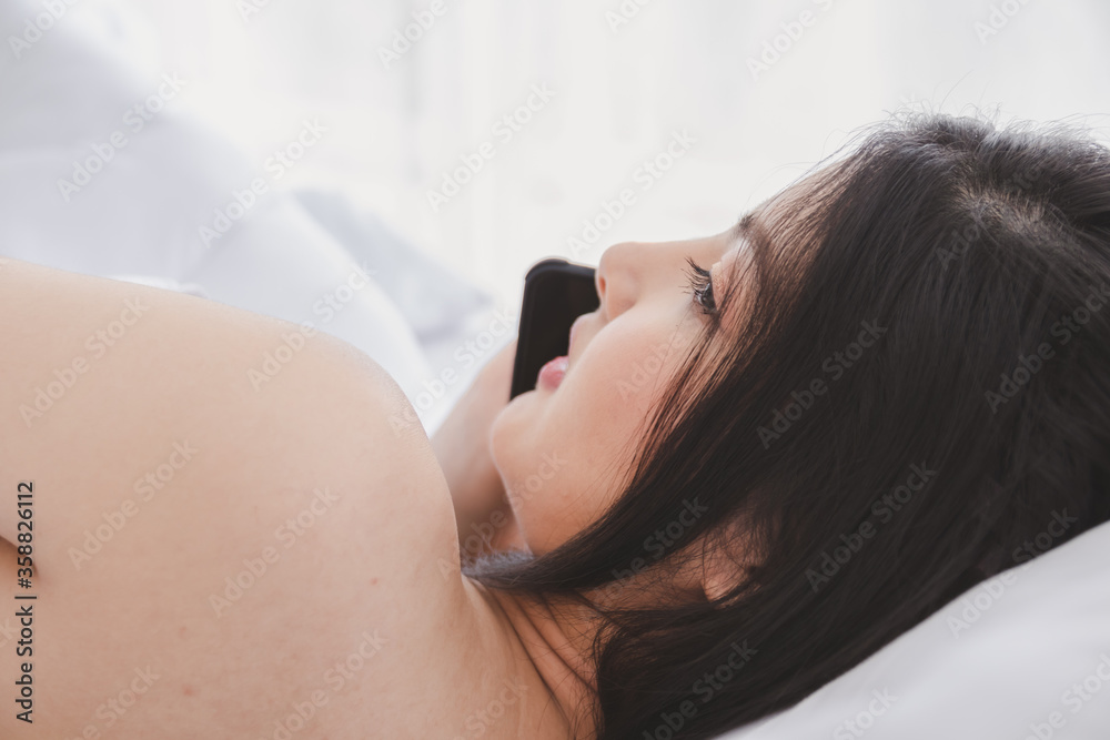 Asian beautiful girl wearing casual clothes and Lying on the bed and talking with smartphone. Asian beautiful girl wearing casual clothes and Lying on the bed and talking with smartphone.