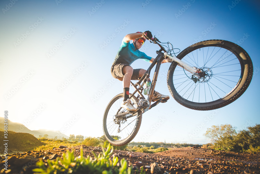Fototapeta premium Wide angle view of a mountain biker speeding downhill on a mountain bike track.
