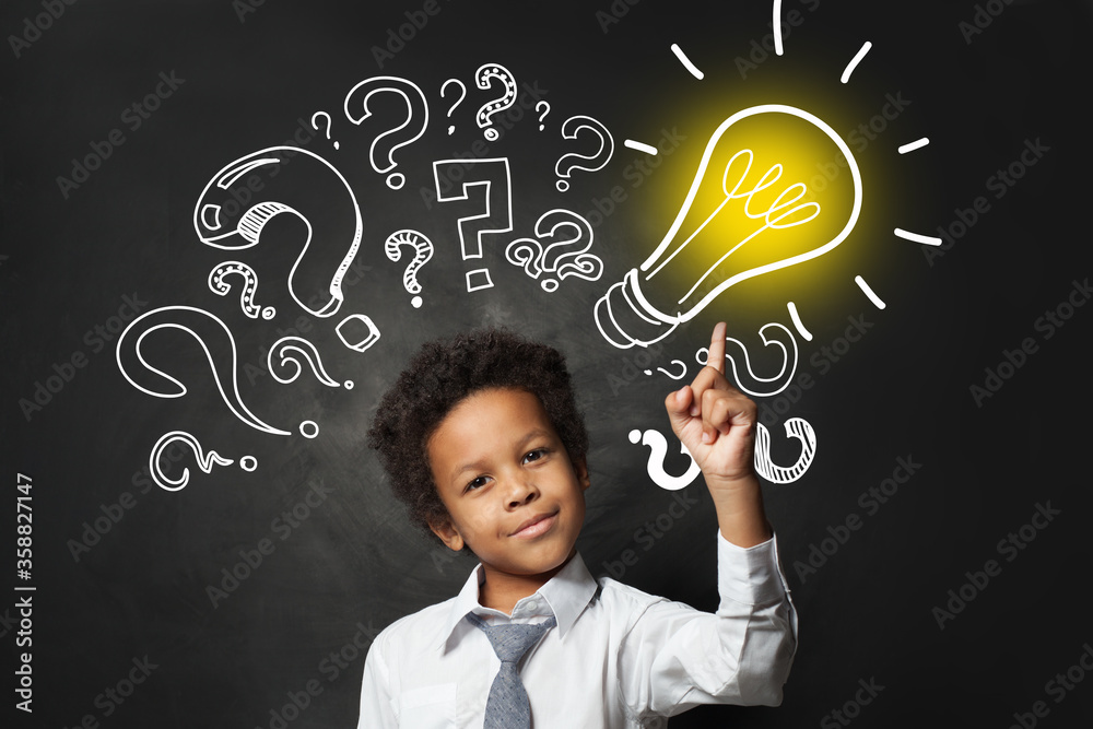 Successful black child student pointing at lightbulb. Brainstorming and idea concept - obrazy, fototapety, plakaty 