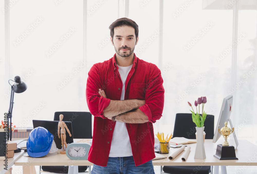 CEO Handsome man standing with arms crossed smile and look at the camera In modern office. CEO Handsome man standing with arms crossed smile and look at the camera In modern office.