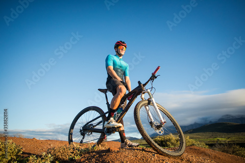 Close up portrait of a mountain biker on his mountain bike on a bike track © Dewald