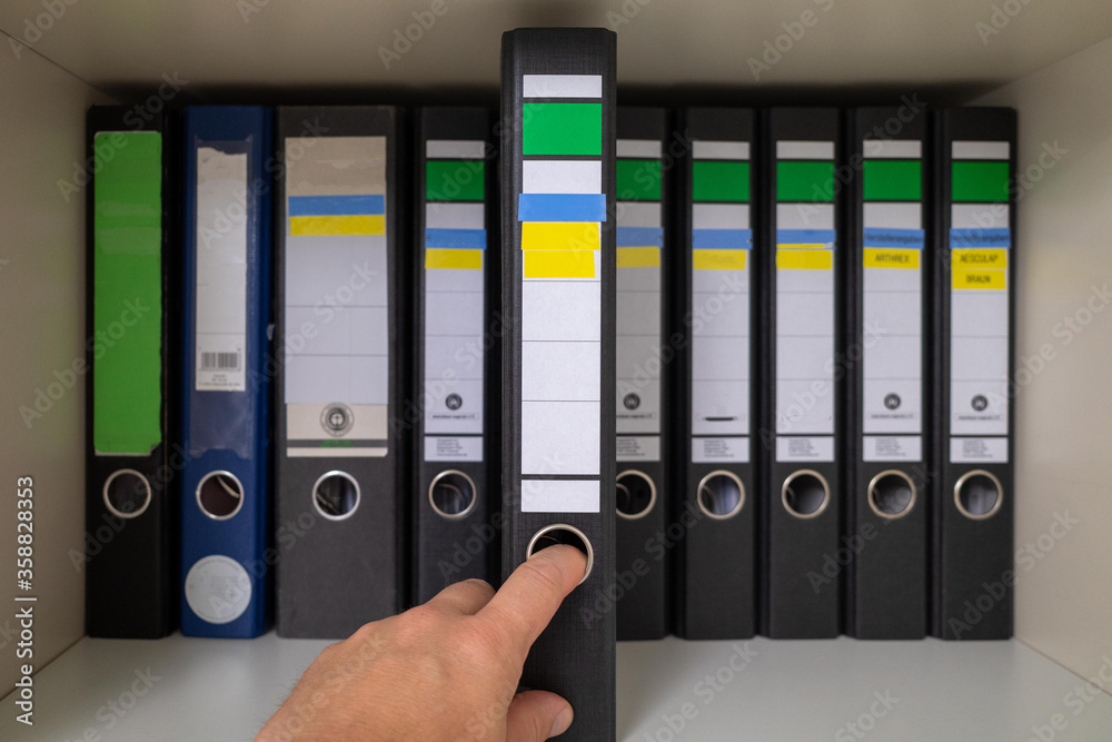 file is taken out of a closet with many files file is taken out of a closet with many files