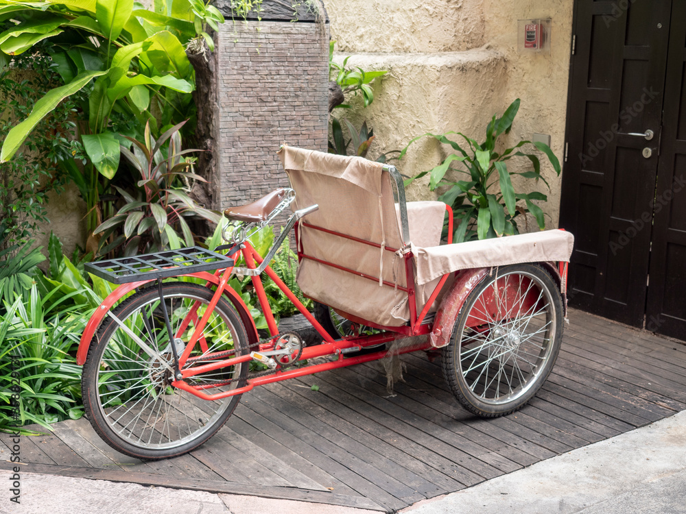 Red housekeeping tricycle cart in front of the resort door.