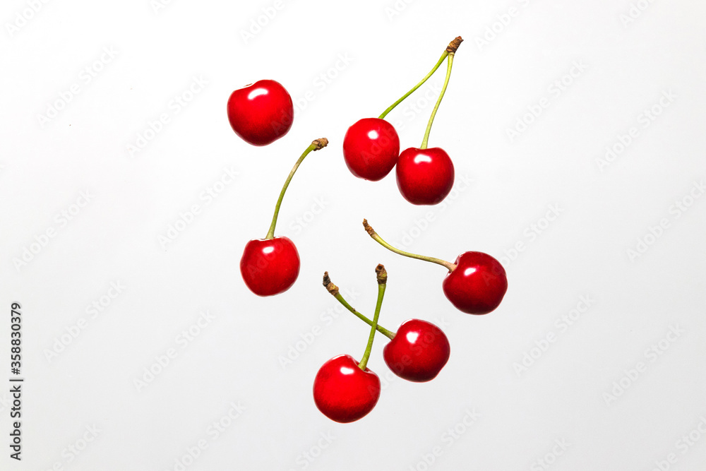 Ripe cherry berry levitating on a grey background. Cherry pattern. Berry summer background. Flat lay, top view, copy space Ripe cherry berry levitating on a grey background. Cherry pattern. Berry summer background. Flat lay, top view, copy space
