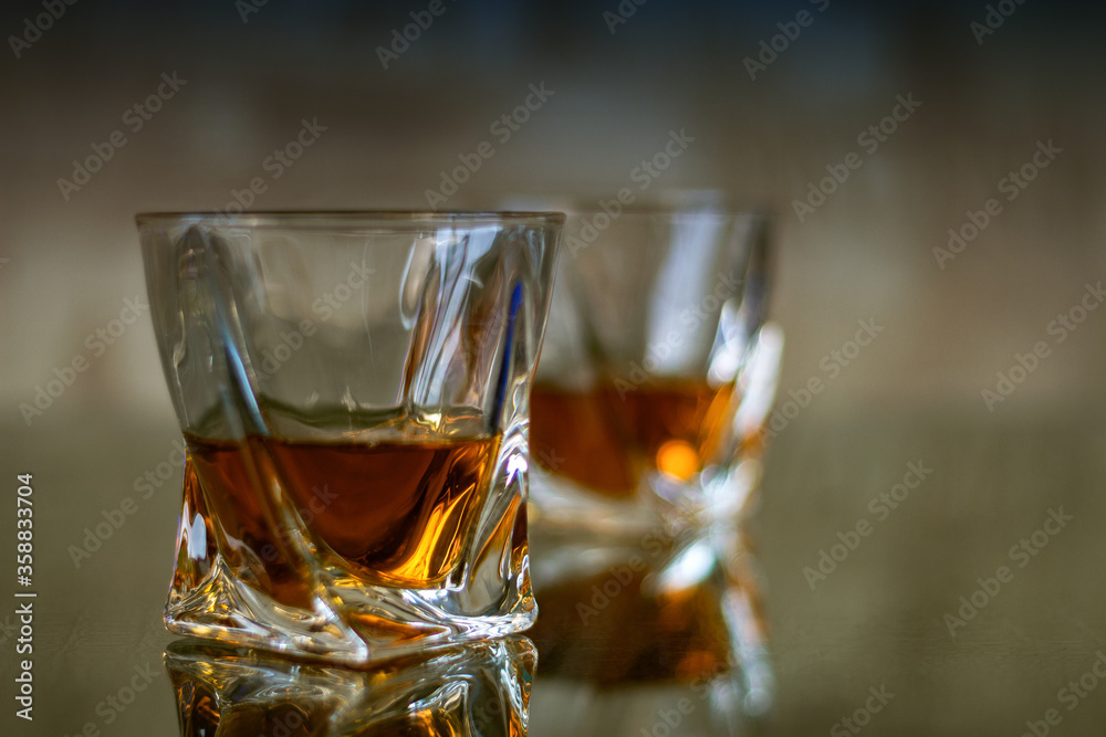 Glasses of whiskey are on the table. Tinted photo with filter Glasses of whiskey are on the table. Tinted photo with filter