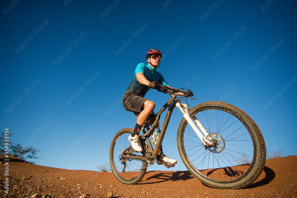 Wide angle view of a mountain biker speeding downhill on a mountain bike track.