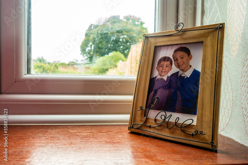 Fotografía A school photo of young brothers in a picture frame on a widow sill