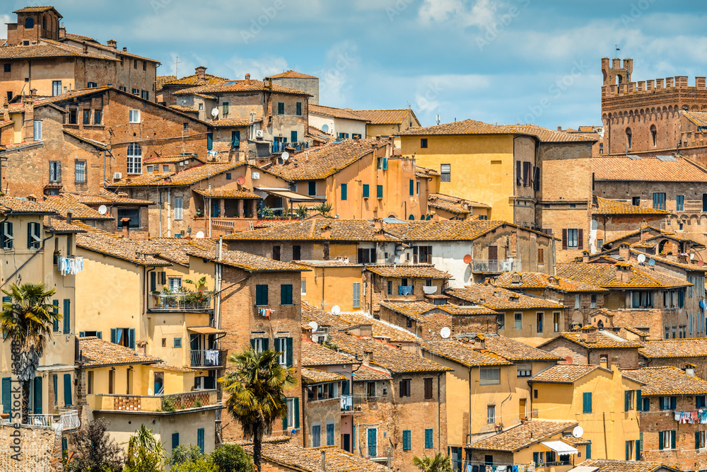 The skyline of a densely built up section of the historic centre seen from a path near Monastero di Sant'Agostino, Siena, Tuscany, Italy, in May.