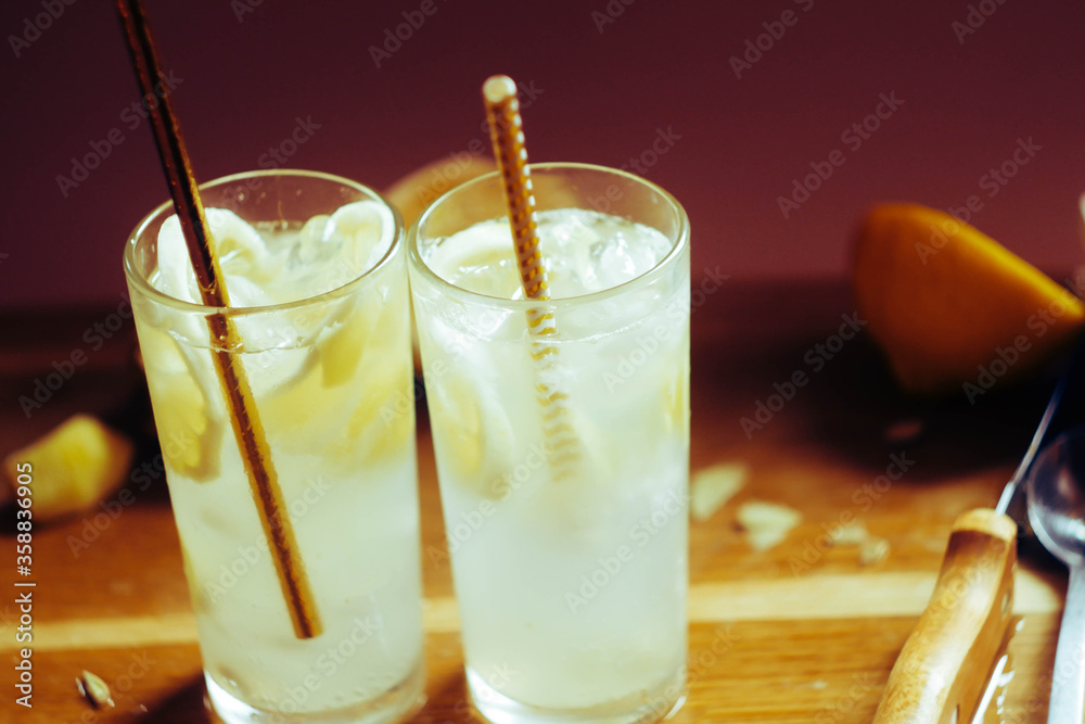 custom made wallpaper toronto digitalLemonade in glass with ice cubes. Summer party refreshing drink. Lemon peel and ginger root. Background wooden desk.