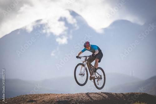 Close up image of a mountain biker speeding downhill on a mountain bike track © Dewald