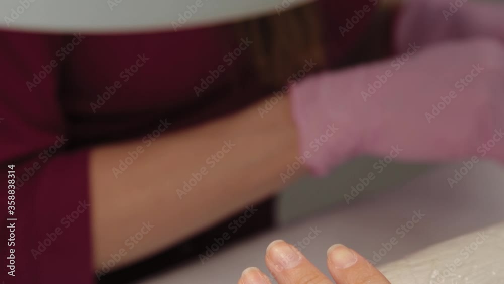 Manicurist raises cuticles with a special tool. Manicurist raises cuticles with a special tool.