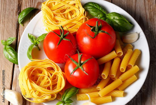 Prodotti tipici italiani. Pasta pomodoro aglio e basilico crudi. Dieta mediterranea.