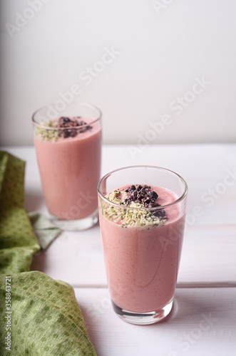 Two strawberry raspberry smoothies with hemp seed and cocoa topping