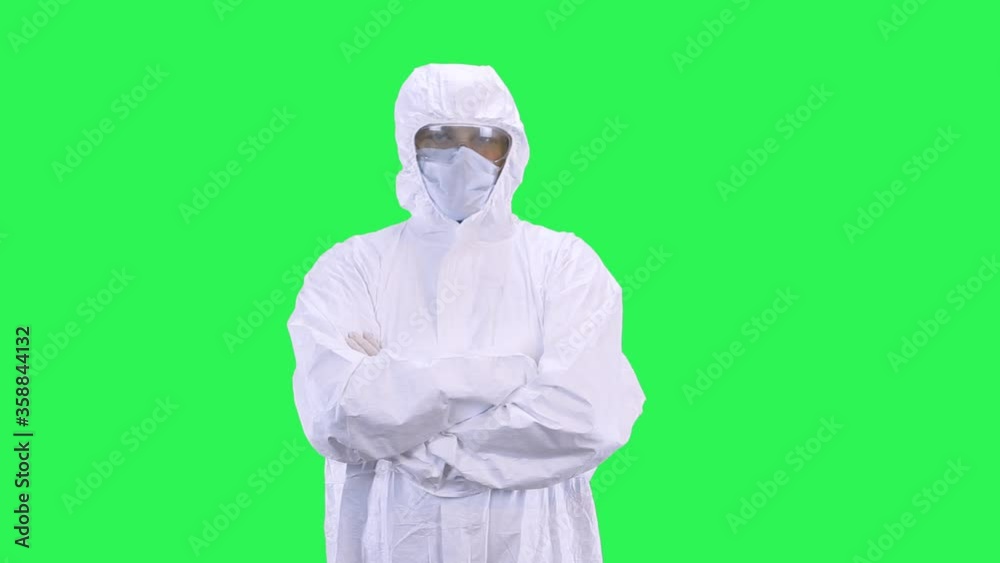 A man in a protective suit with a mask on his head and glasses stands on an angry background A man in a protective suit with a mask on his head and glasses stands on an angry background
