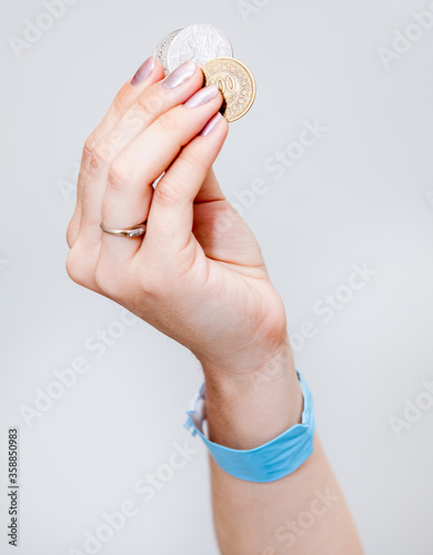 Female hand holding Tunisian coins money, grey background photo