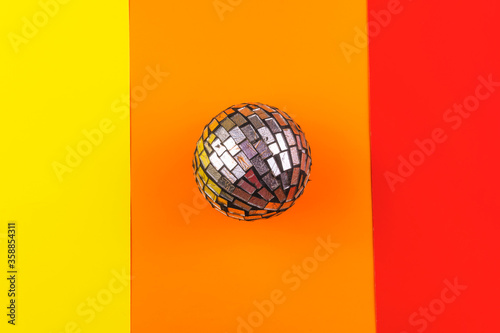 esfera reflejante sobre una superficie colorida en tonos cálidos naranja amarillo y rojo photo