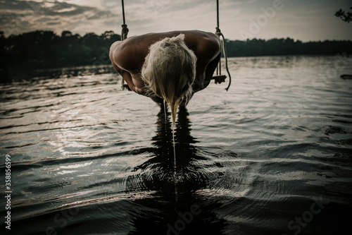 Woman lying on swing over lake