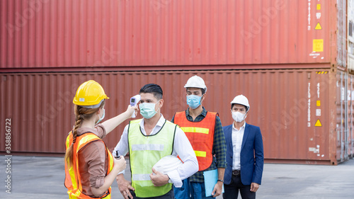 New normal concept,Inspection Engineer Team Protect yourself by checking the temperature, wearing mask and helmet Before entering warehouse or factory Prevent accident from work dust and Coronavirus
