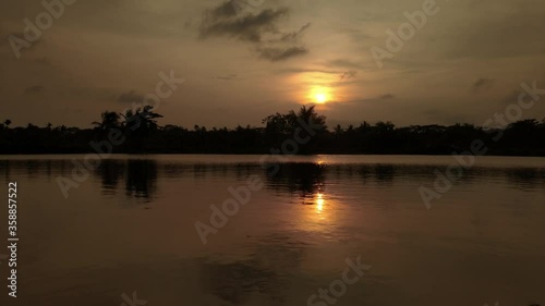 Orange Sun is Reflecting in The Water at sunset. Small wave on the water Background