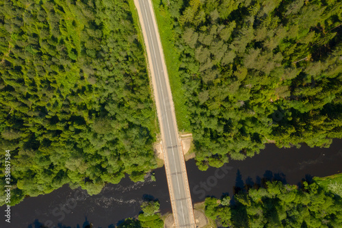 Aerial high angle view of highway and bridge over river in deep forest, Moscow area, Russia
