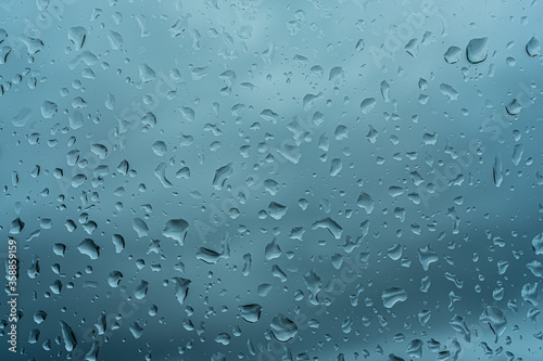 Raindrops on the window. Beautiful closeup. Blue background. Water splash. Natural background. High quality photo